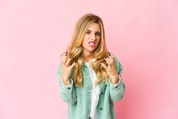 Young blonde woman upset screaming with tense hands