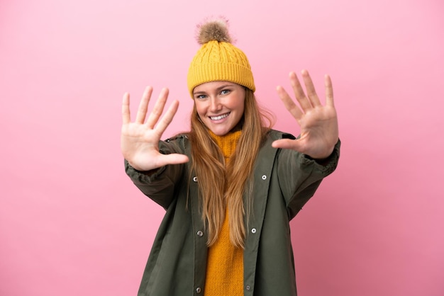 Young blonde woman wearing winter jacket isolated on pink background counting ten with fingers