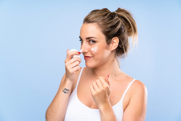 Young blonde woman with moisturizer