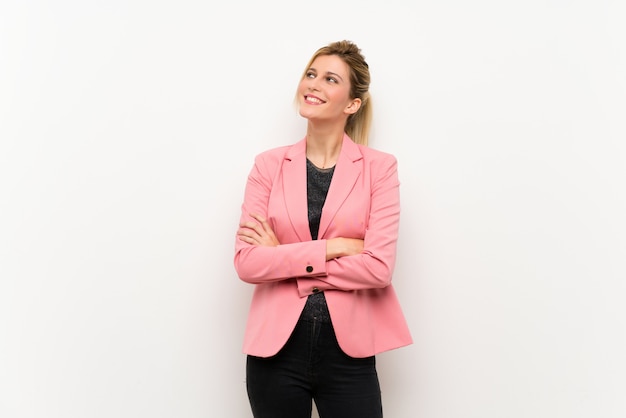 Young blonde woman with pink suit looking up while smiling