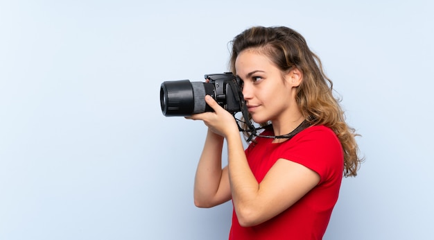 Young blonde woman with a professional camera