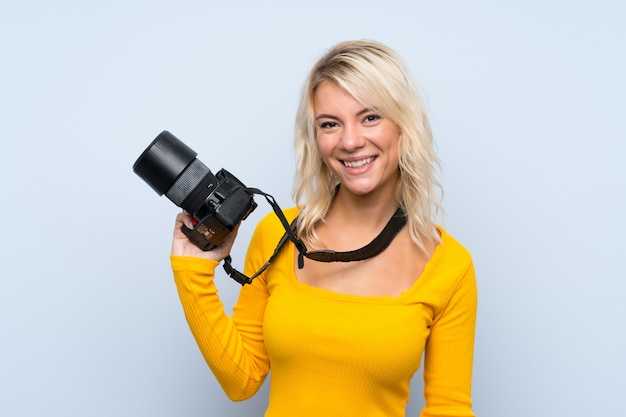 Photo young blonde woman with a professional camera