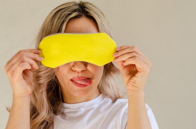 Young blonde woman with sleeping mask having fun and relaxing at home Wellness and chilling concept quality of sleep good night insomnia relaxation healthy night sleep