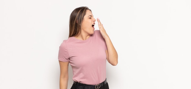 Young blonde woman yawning lazily early in the morning, waking and looking sleepy, tired and bored