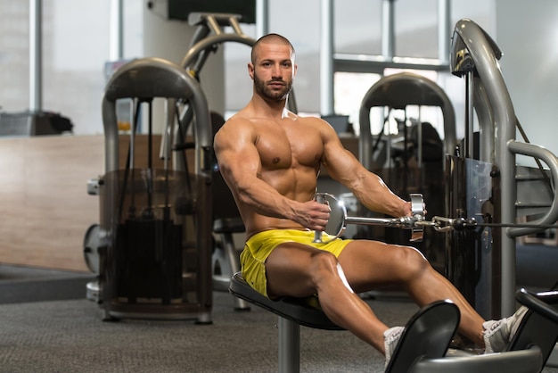 Young Bodybuilder Doing Heavy Weight Exercise For Back On Machine