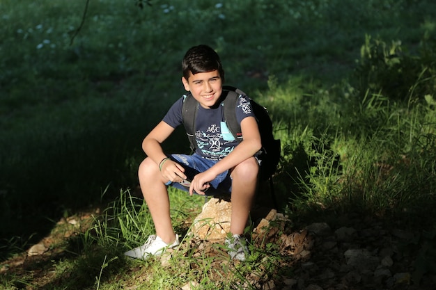 young boy beautiful on a camping trip in the forest summer background