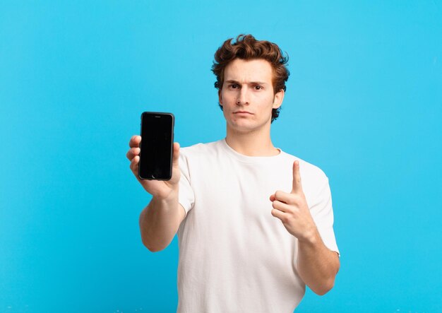 Young boy feeling angry, annoyed, rebellious and aggressive, flipping the middle finger, fighting back. telephone screen concept