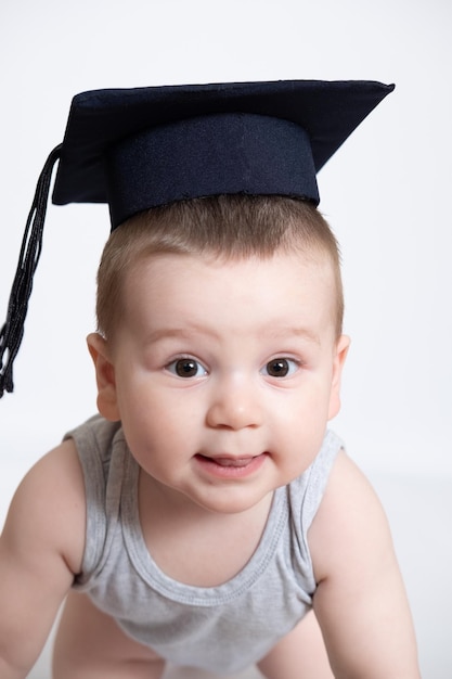 A young boy has a graduation black cap with a tassel on a white isolated background Use it for a school or education concept