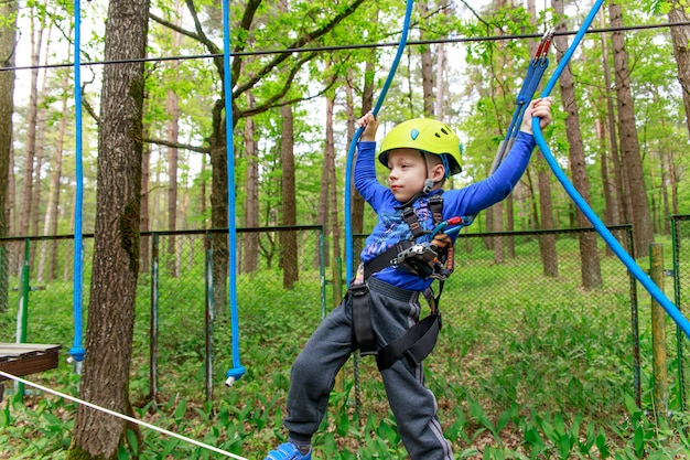 Young boy in helmet walks by rope