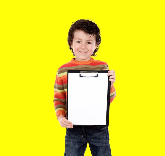 Young boy holding a clipboard isolated on a yellow background v