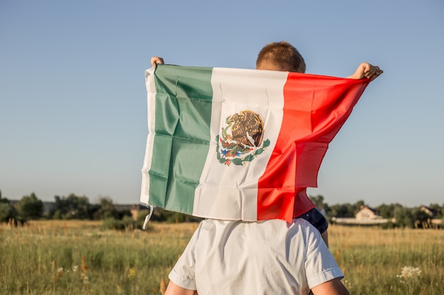 Young boy holding flag of Mexico. "September 16. Independence Day of Mexico. Mexican War of Independence, 1810."