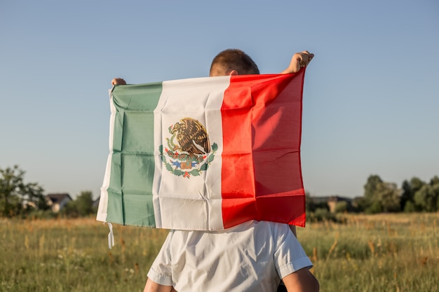 Young boy holding flag of Mexico. "September 16. Independence Day of Mexico. Mexican War of Independence, 1810."