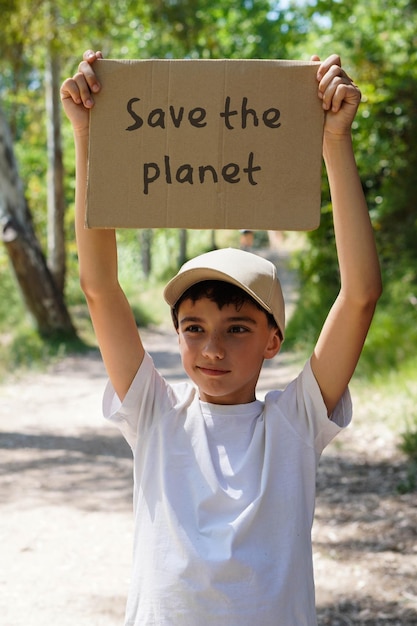 a young boy holds a sign that says save the planet