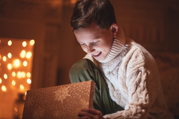 young boy opening a gift at night