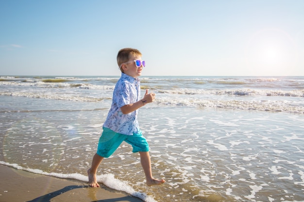 Young boy run on the shore