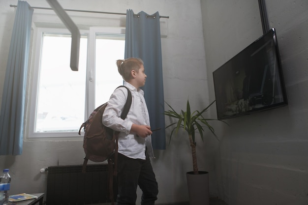 Young boy watching tv before going to school