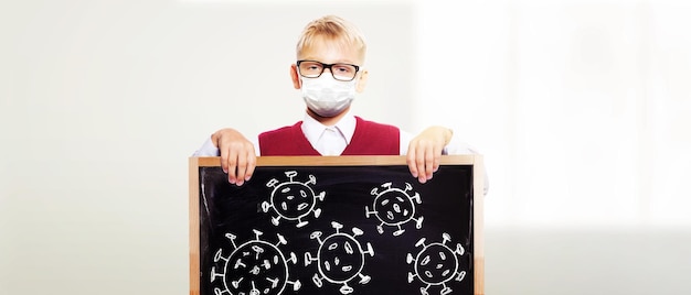 Young boy with protection mask against corona virus at school