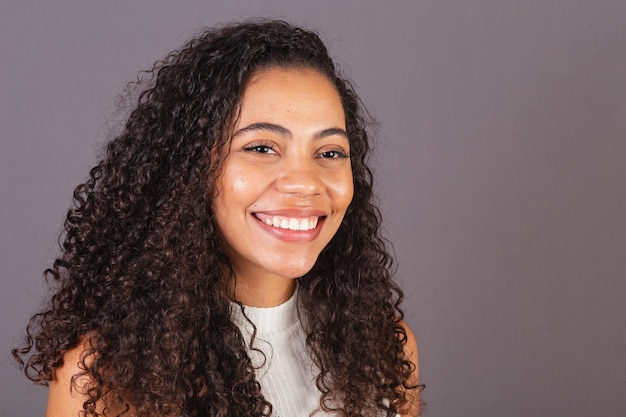 Young Brazilian black woman closeup photo smiling looking at camera white teeth smile