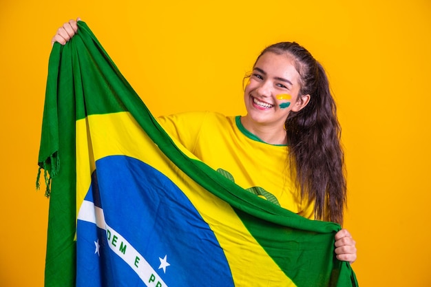 Young brazilian cheerleader with a brazil flag smiling happily