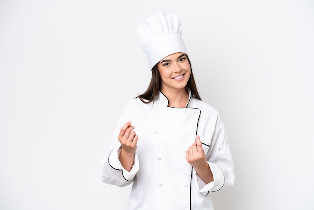 Young Brazilian chef woman isolated on white background making money gesture