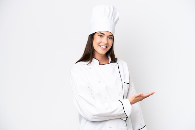 Young Brazilian chef woman isolated on white background presenting an idea while looking smiling towards