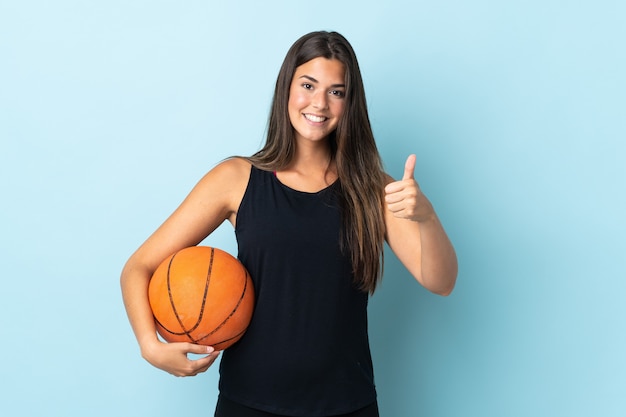 Young brazilian girl isolated playing basketball and with thumb up