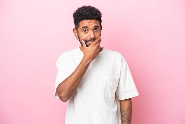 Young Brazilian man isolated on pink background thinking