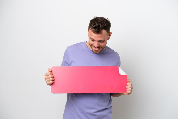 Photo young brazilian man isolated on white background holding an empty placard