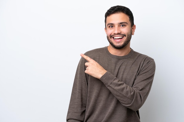 Young Brazilian man isolated on white background surprised and pointing side