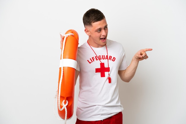 Young brazilian man isolated on white background with lifeguard equipment and pointing finger to the side