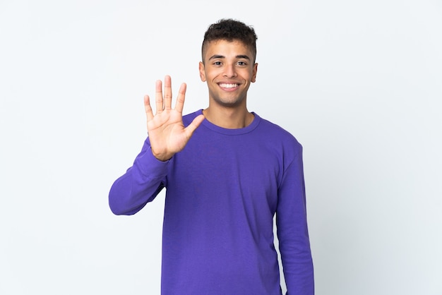 Young brazilian man isolated on white wall counting five with fingers