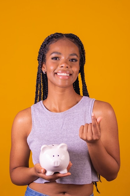 Young Brazilian woman holding piggy bank and coin concept of economy finance saving