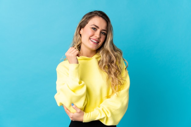 Young Brazilian woman isolated on blue background laughing