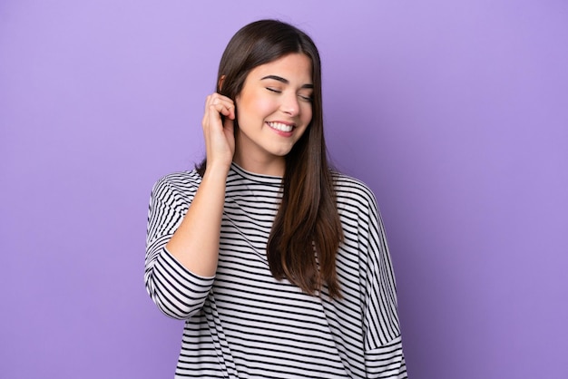 Young Brazilian woman isolated on purple background laughing