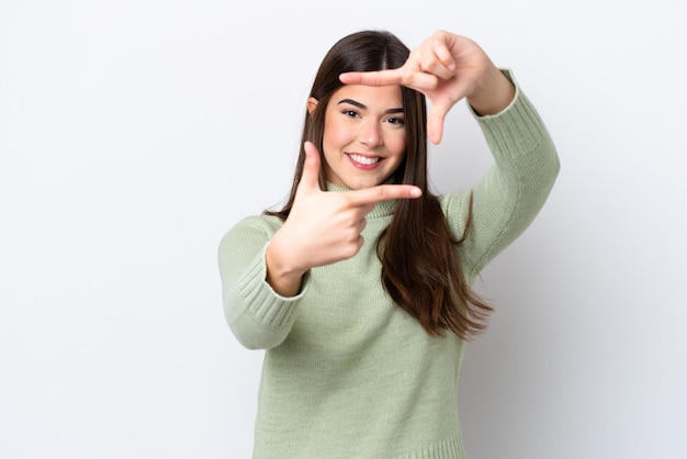 Young Brazilian woman isolated on white background focusing face Framing symbol