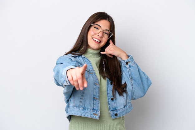 Young Brazilian woman isolated on white background making phone gesture and pointing front