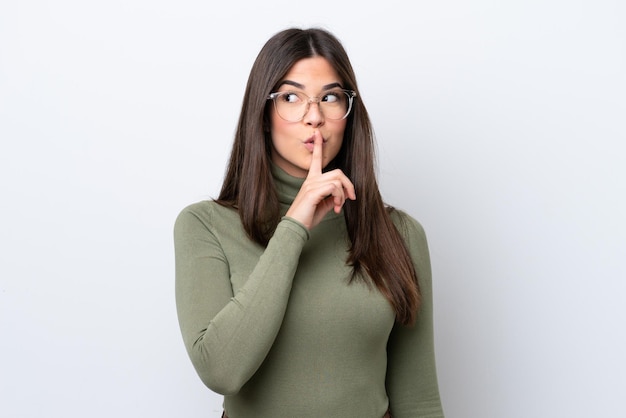 Young Brazilian woman isolated on white background showing a sign of silence gesture putting finger in mouth