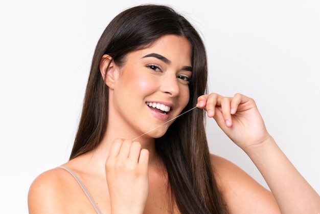 Young Brazilian woman isolated on white background using dental floss with happy expression Close up portrait