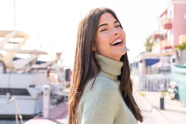 Young Brazilian woman at outdoors With happy expression