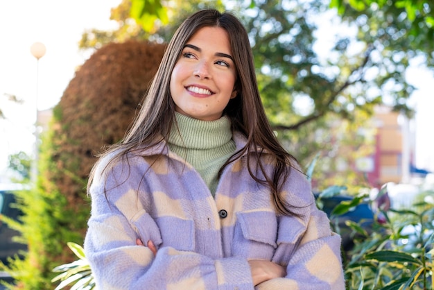 Young Brazilian woman in a park looking up while smiling