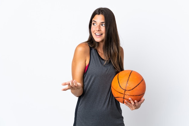 Young brazilian woman playing basketball isolated on white background with surprise expression while looking side