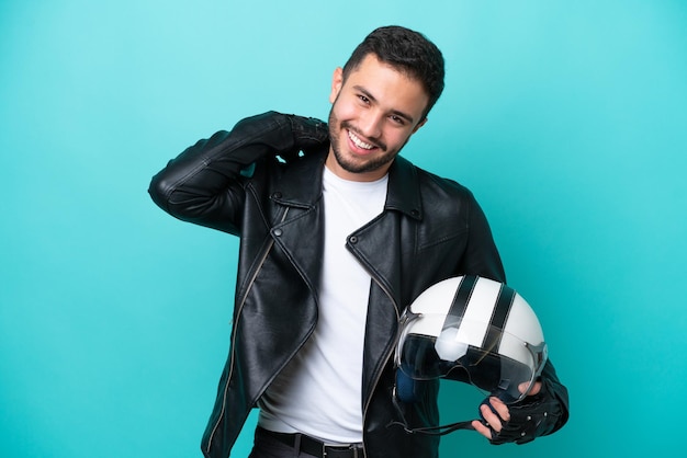 Young Brazilian woman with a motorcycle helmet isolated on blue background laughing