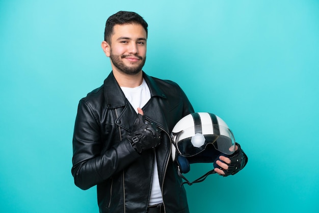 Young Brazilian woman with a motorcycle helmet isolated on blue background proud and selfsatisfied