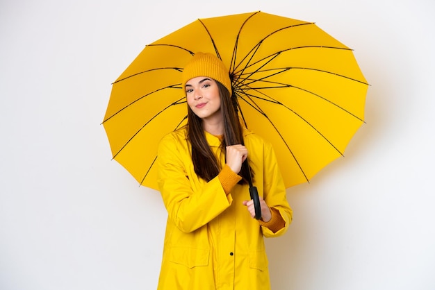 Young Brazilian woman with rainproof coat and umbrella isolated on white background proud and selfsatisfied