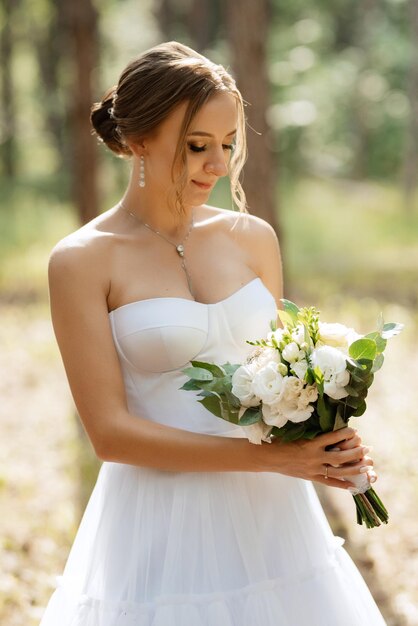 Young bride in a white short dress in a spring pine forest