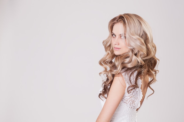 Young bride with a beautiful hairstyle and make-up posing in Studio.  . Copyspace