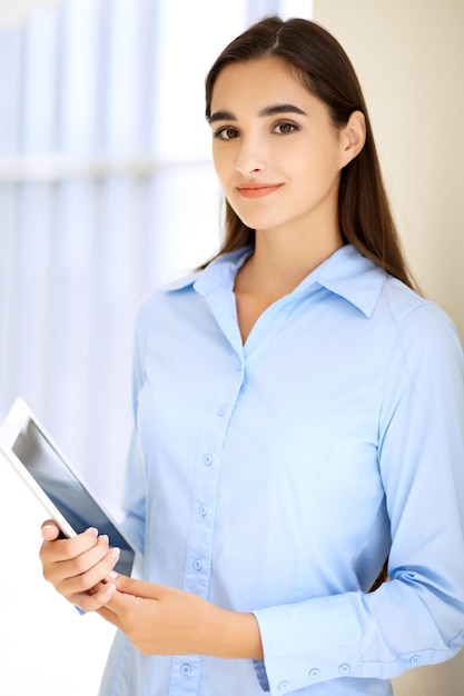 Young brunette businesswoman or student girl looking at camera