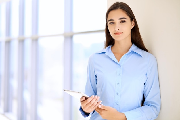 Young brunette businesswoman or student girl looking at camera