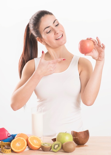 Young brunette female with apple on white background