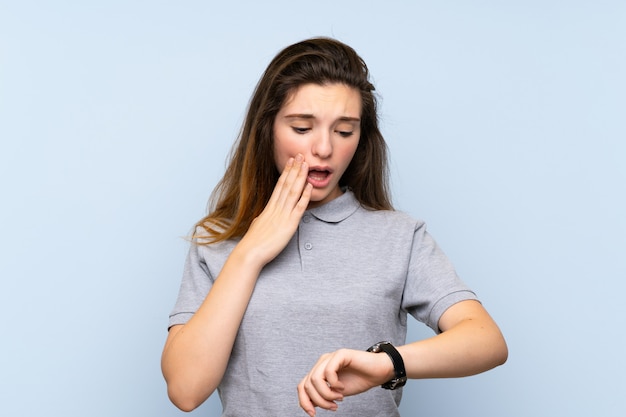 Young brunette girl with wrist watch and surprised